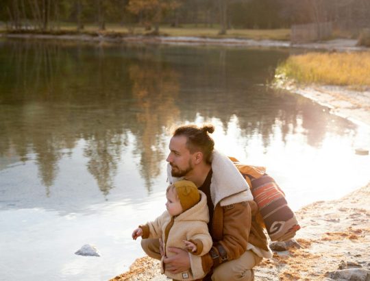 oče in otrok, ki gledata v jezero, jesenska pokrajina